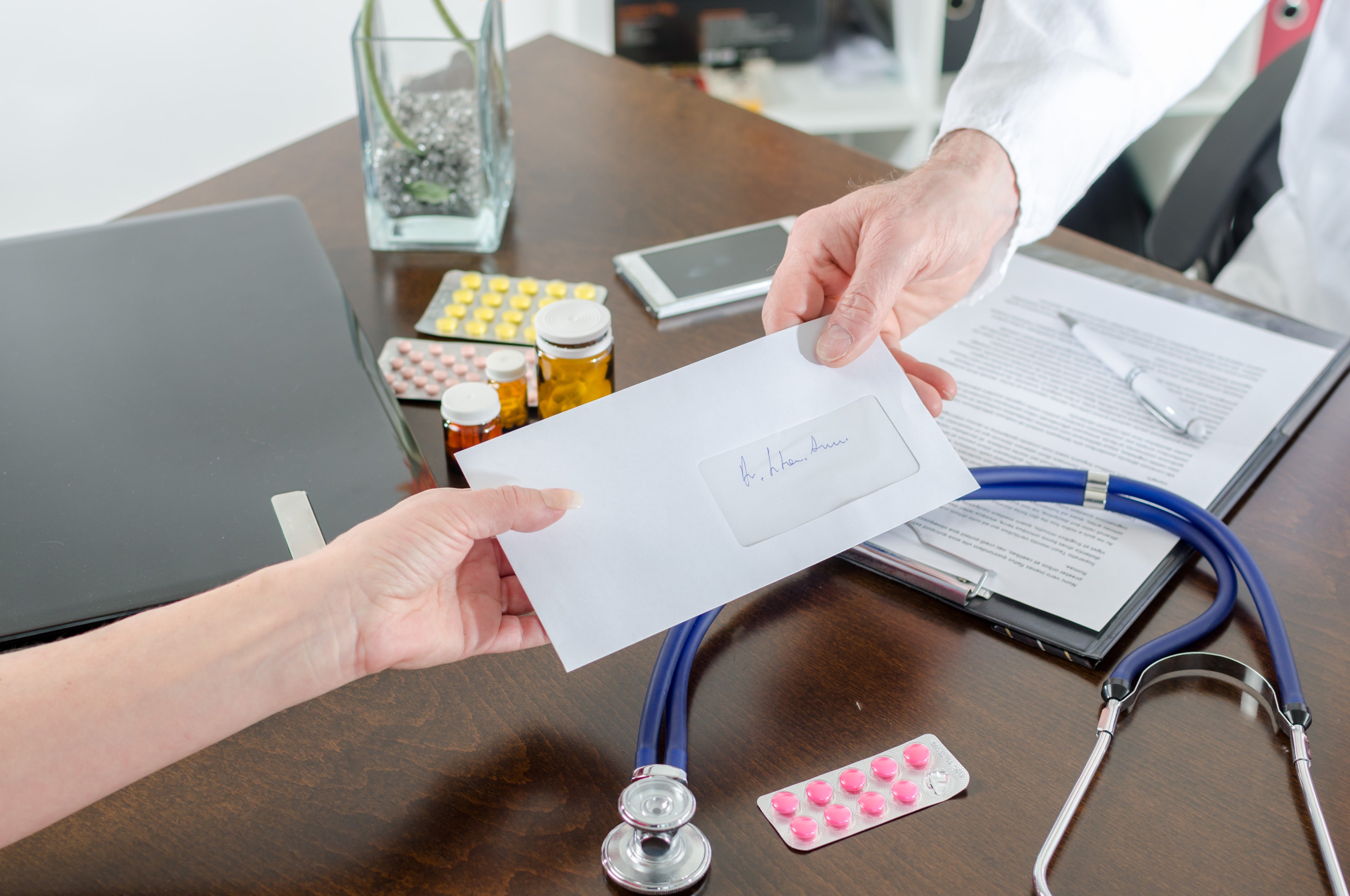 Doctor passing a letter to patient 