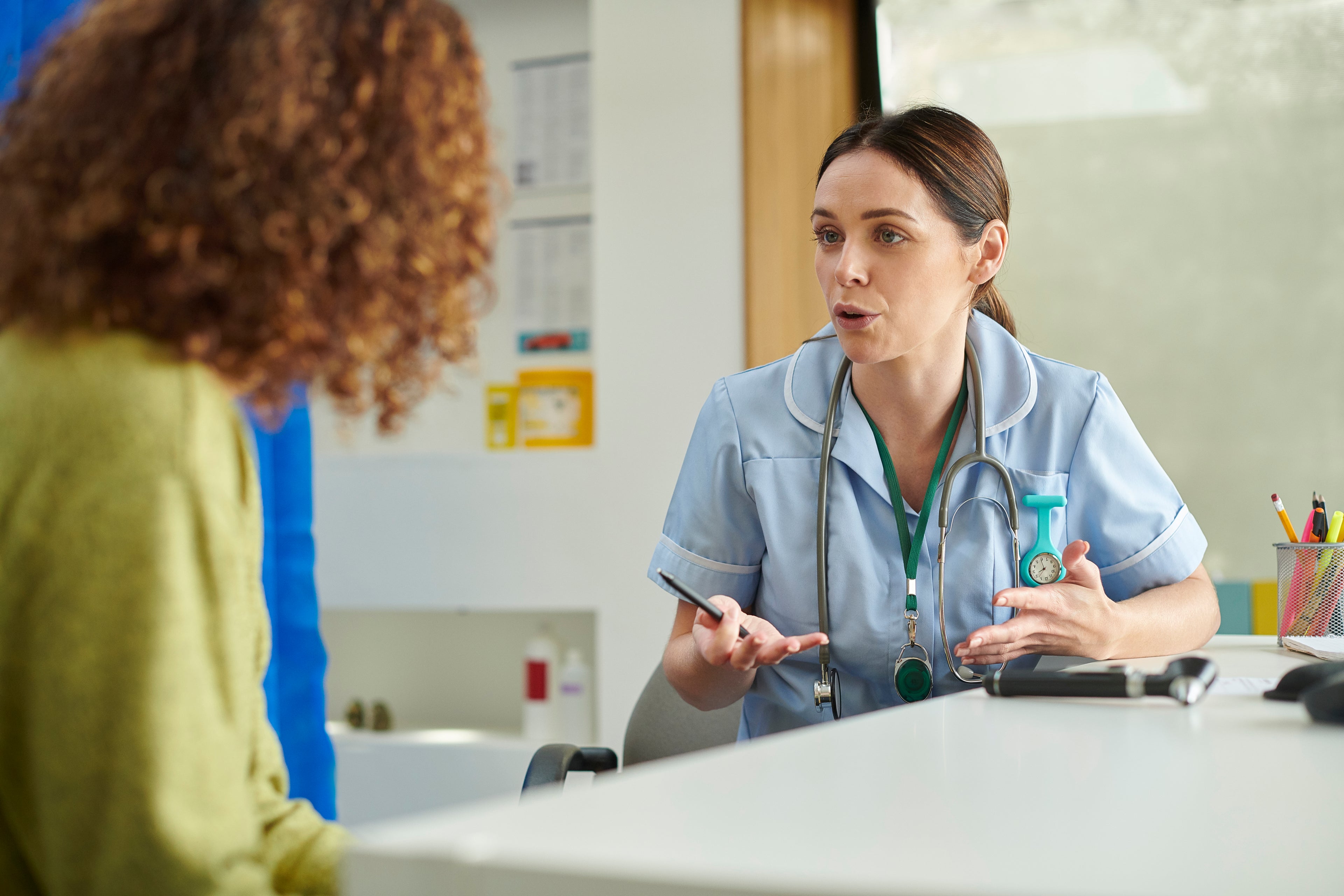 Two nurses looking at documents at a desk