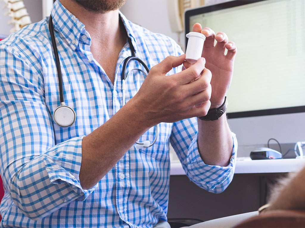 Doctor holding a medication bottle in his two hands
