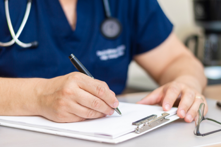 Close up of medical staff filling death certificate