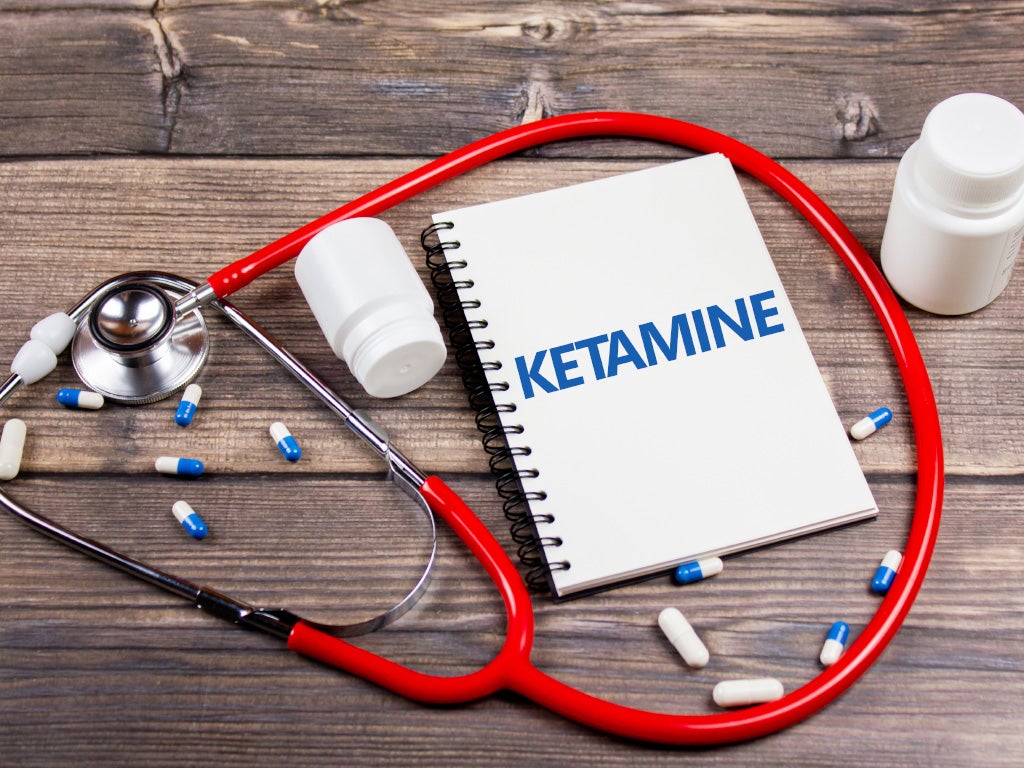 Stethoscope wrapped around a binder folder with the word ketamine written in blue writing