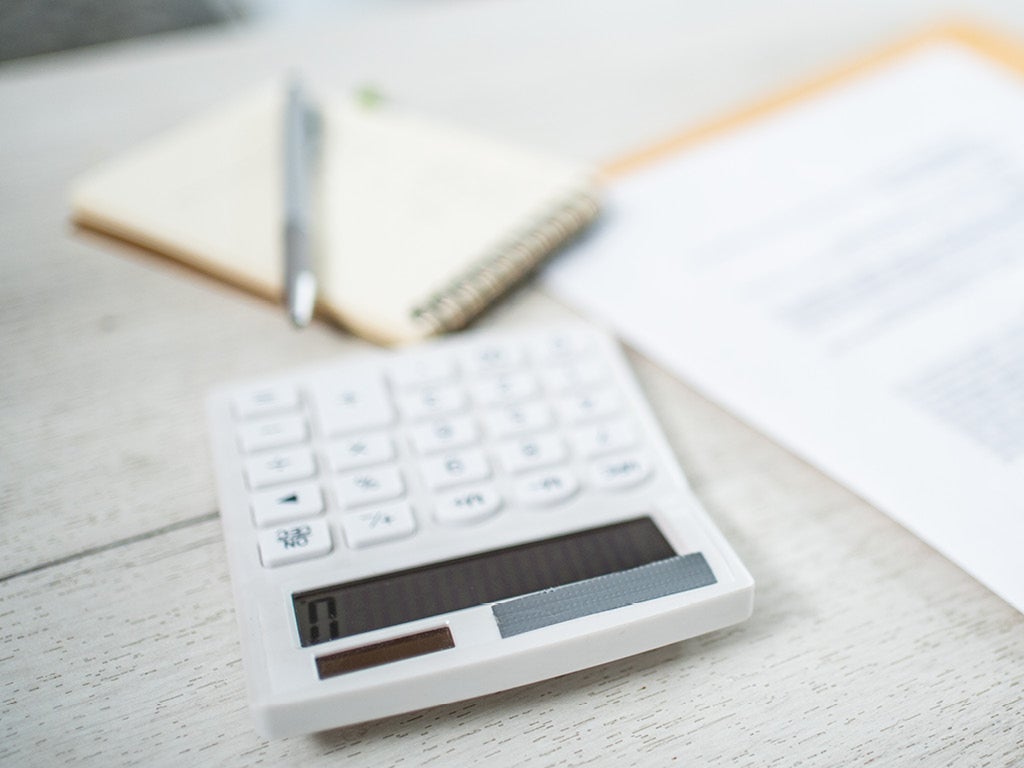 Calculator, pen, notebook and documents on desk