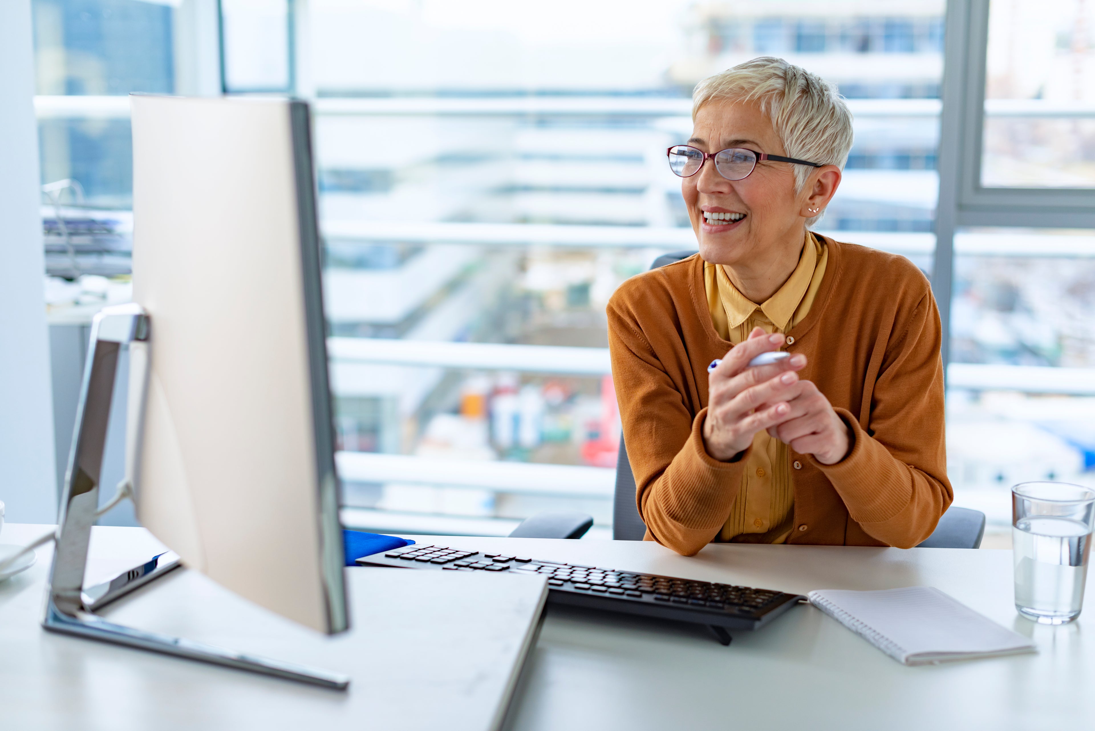 woman smiling at desktop monitor