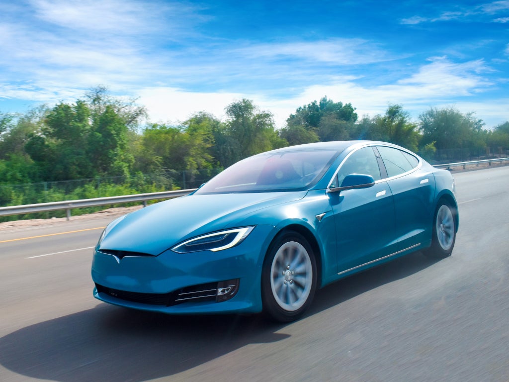 Blue car driving on highway.