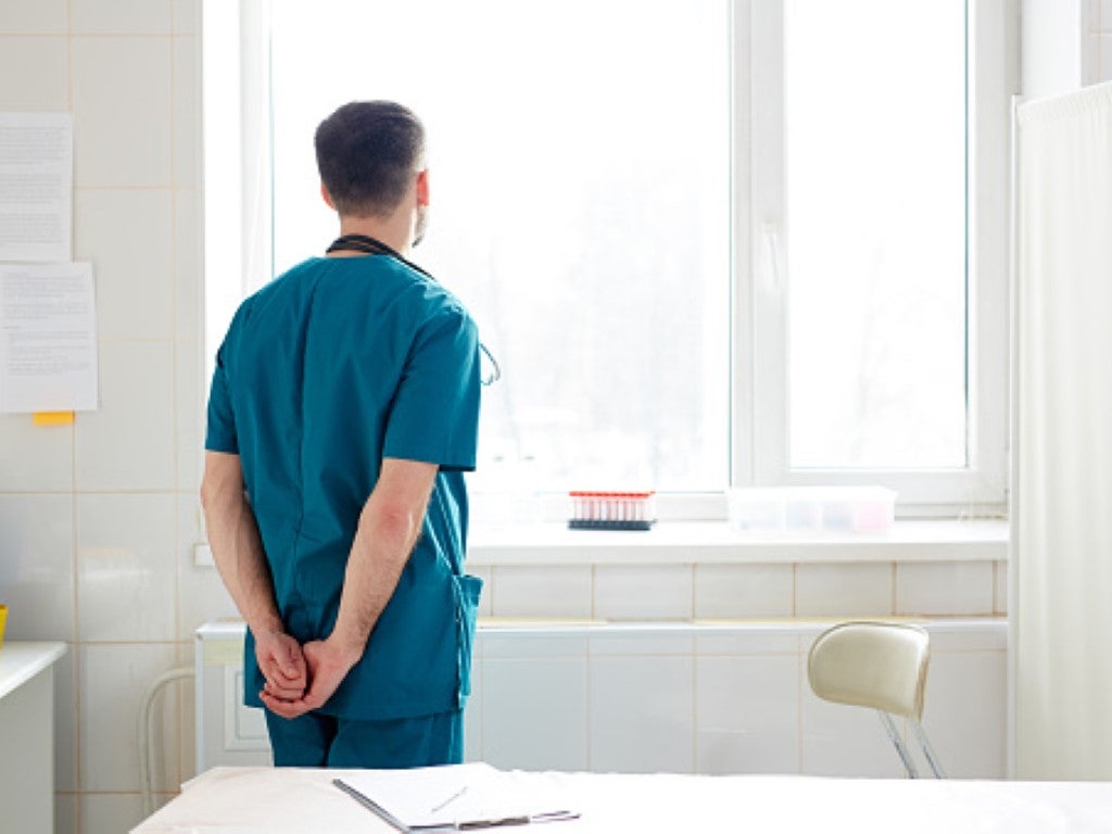 Intern staring out of window into distance