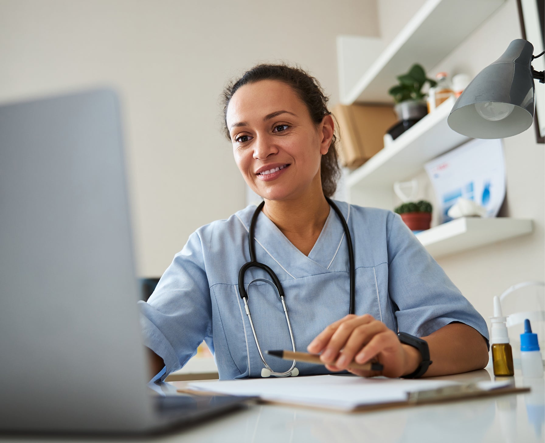 doctor smiling and working on their laptop