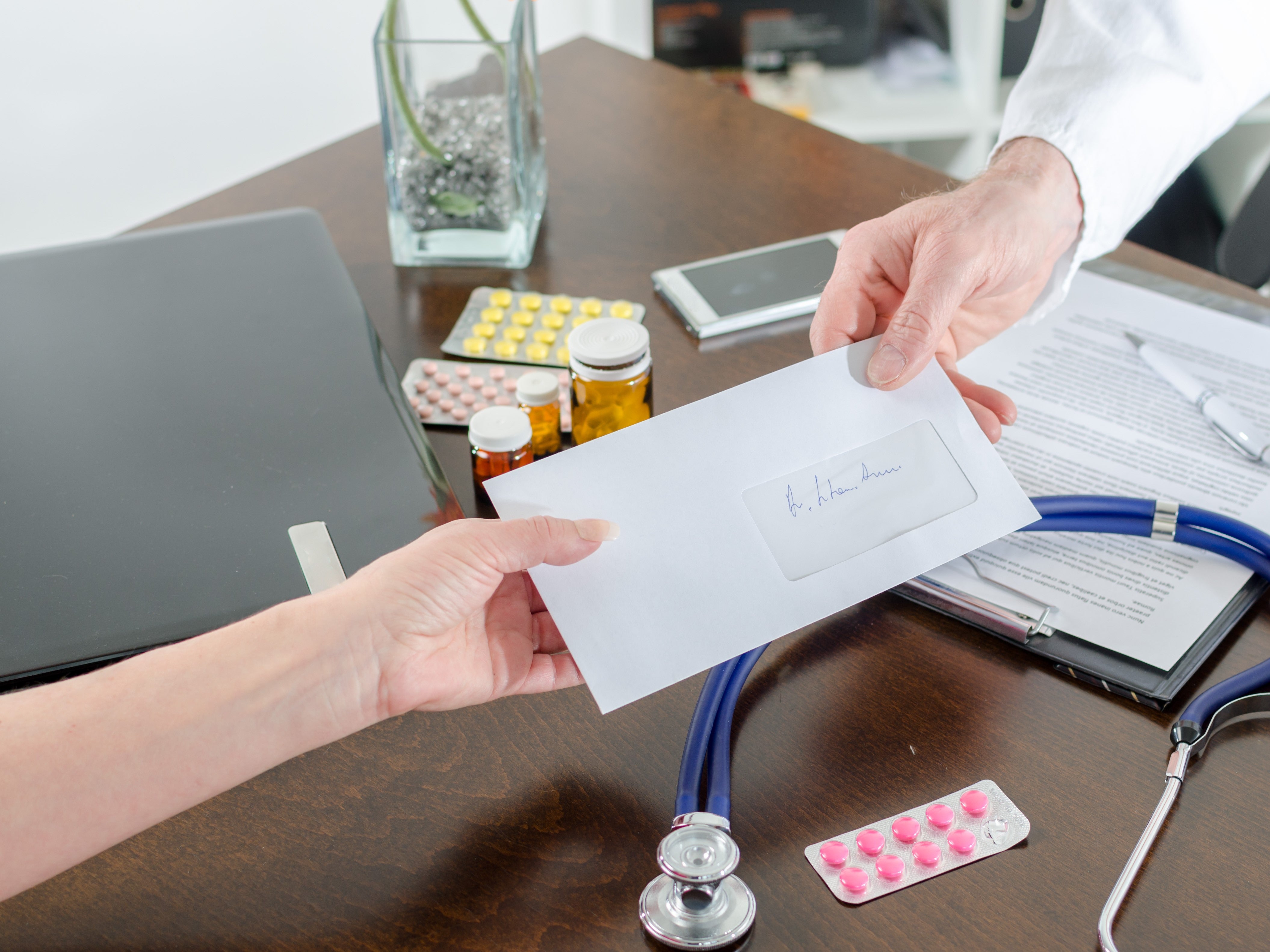 Doctor handing over medical letter to patient