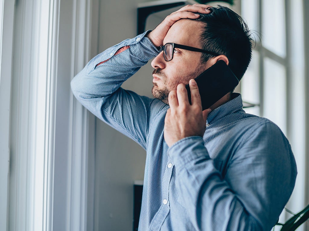 Man on phone looking out window