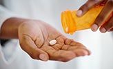 Tablet being poured out of medication bottle