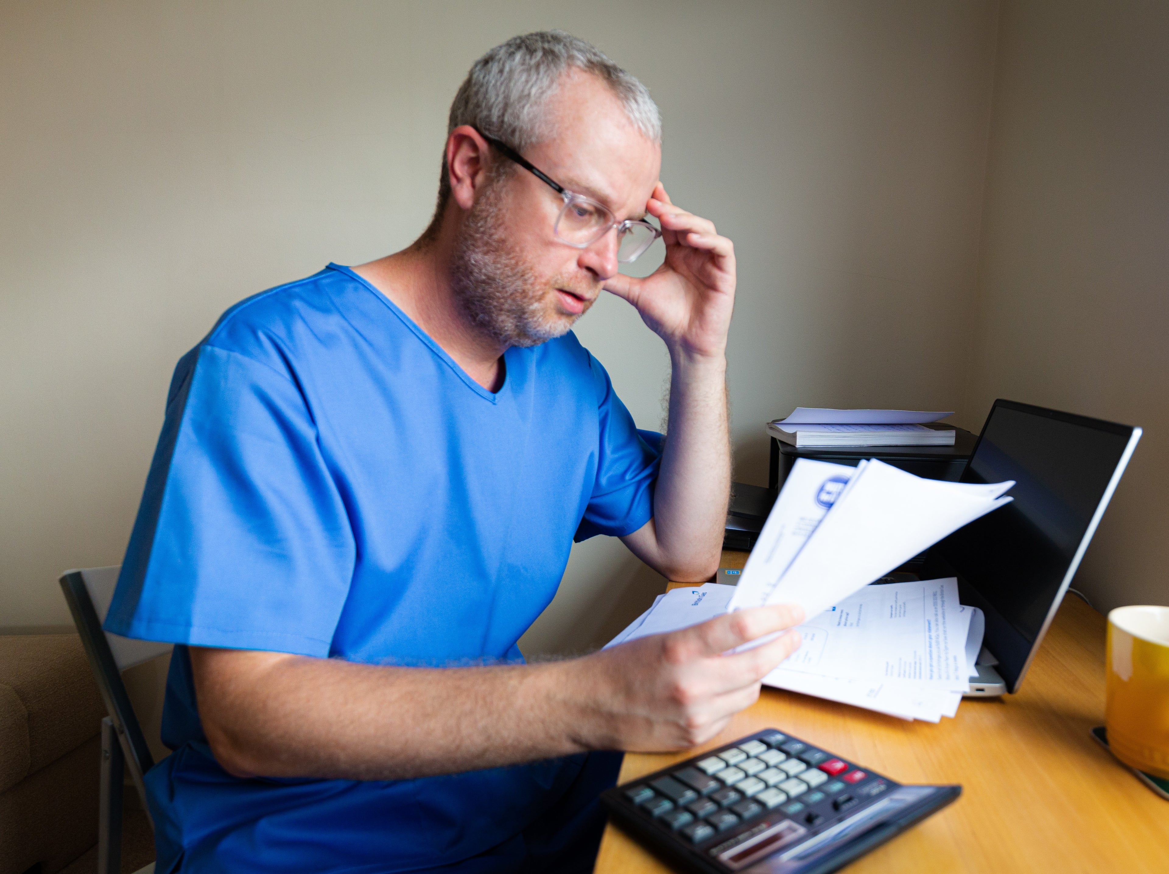 Doctor in scrubs looking at paper