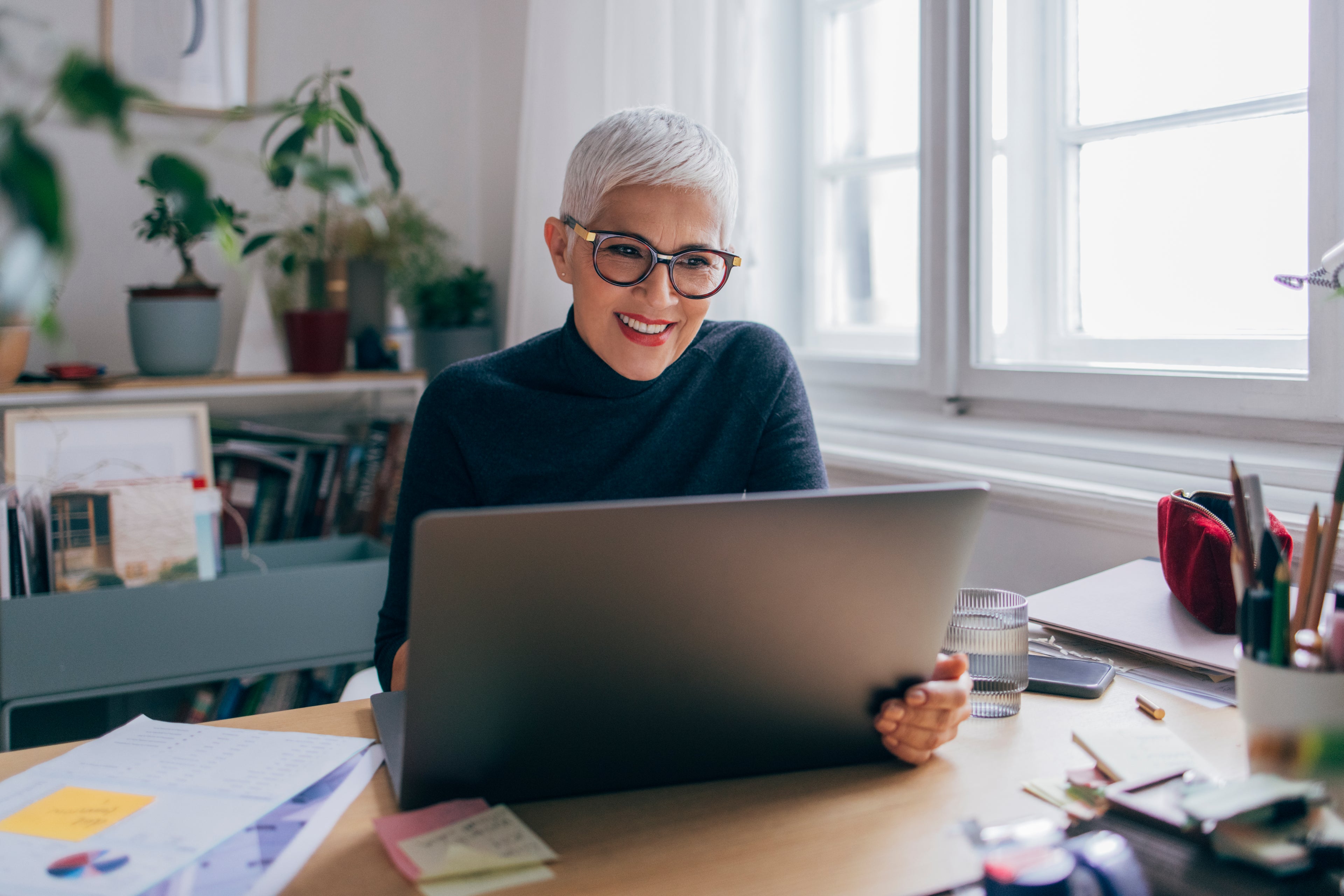 Woman looking and smiling at laptop