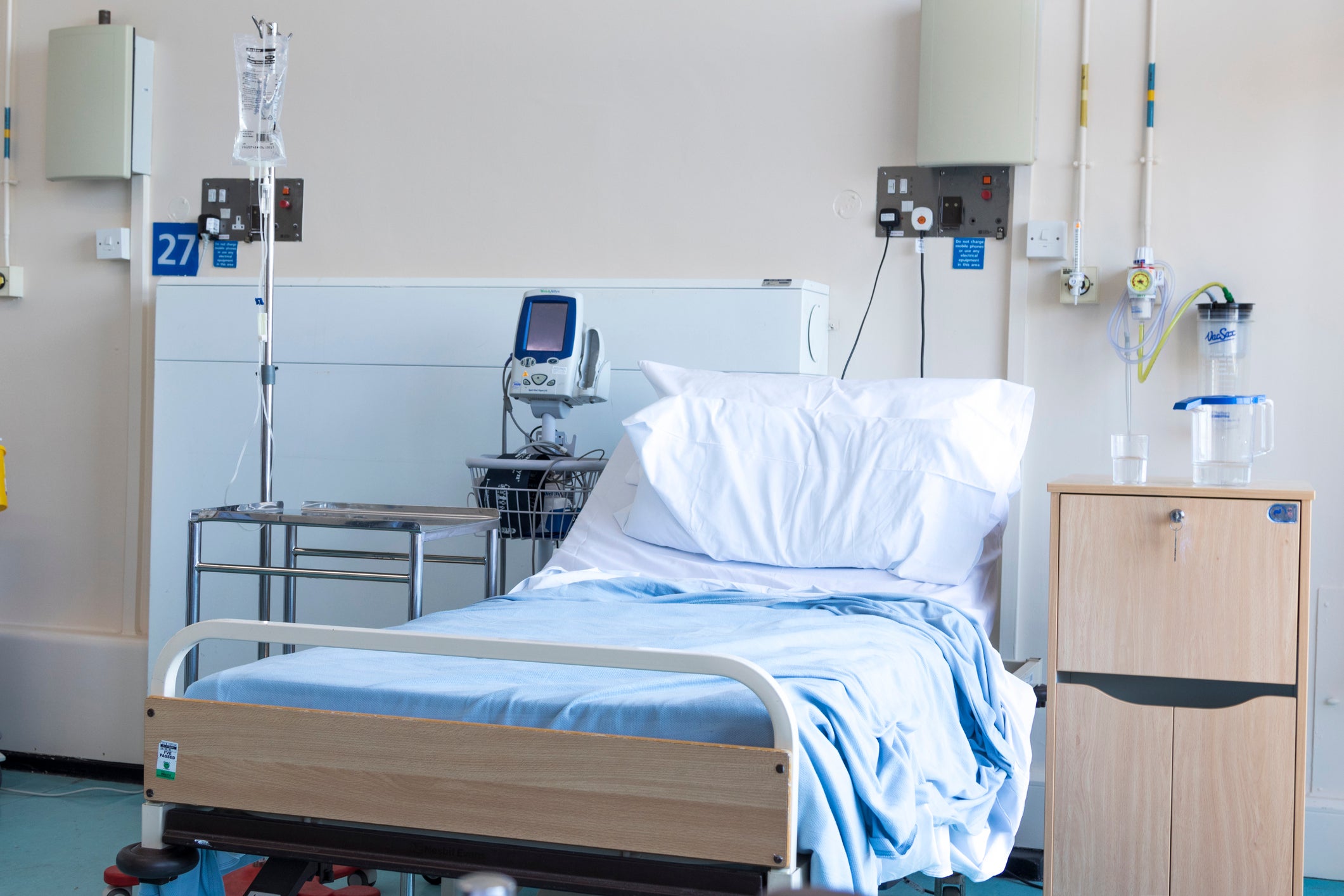 Empty hospital bed with IV pole and line