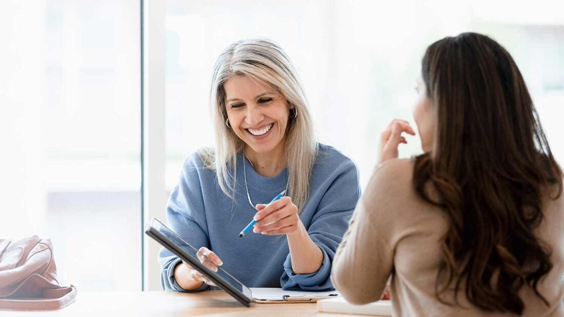 doctor talking patient while using tablet