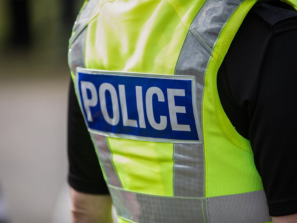 Back of police member showing the blue reflective police writing on the reflective stab vest