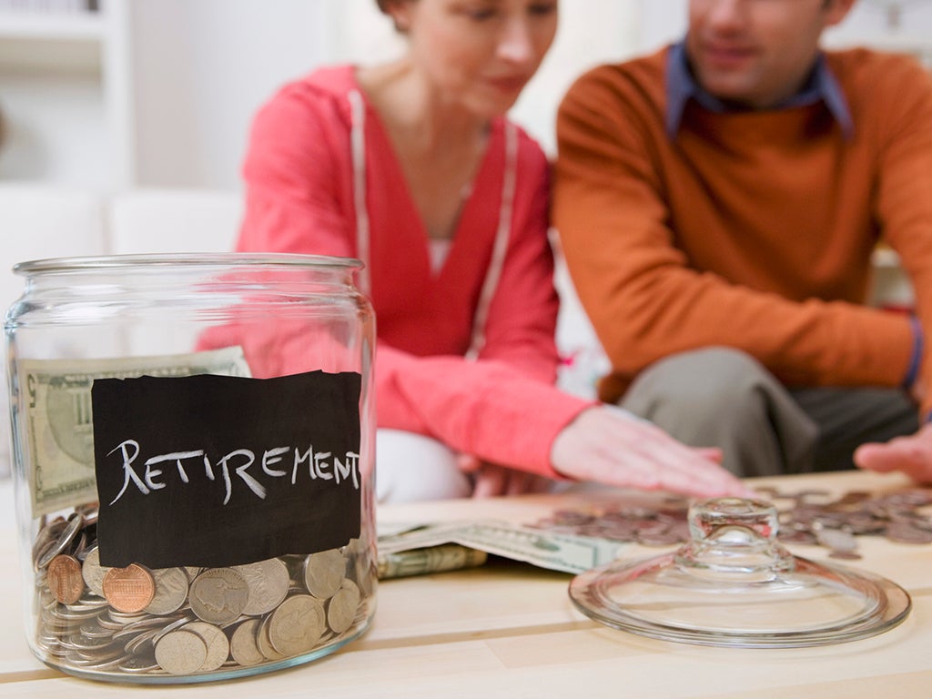 Older man and woman pictured planning retirement behind retirement savings jar