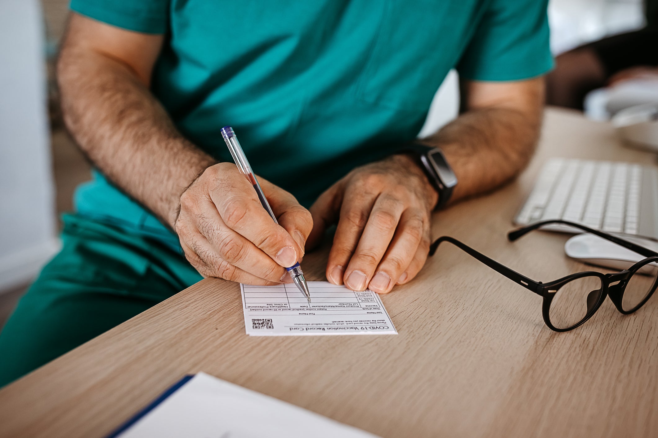 Person writing with pen on Doctor certificate file