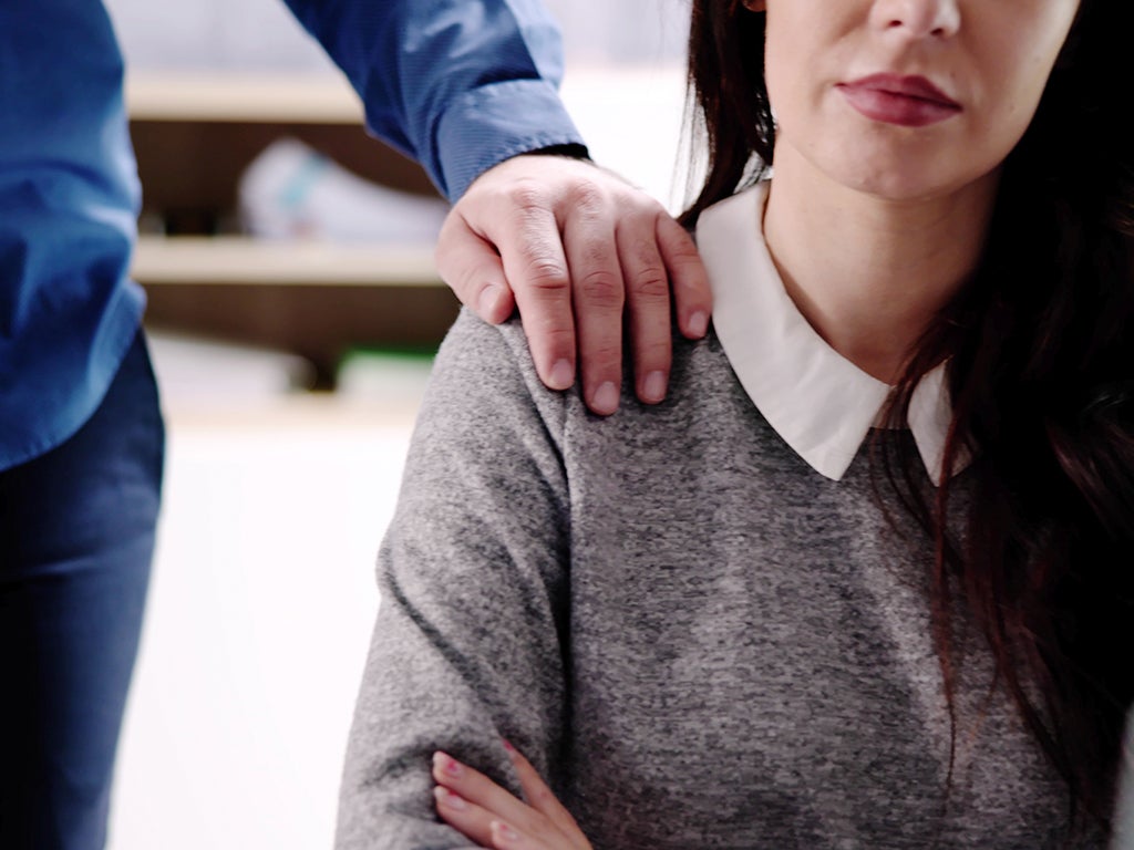 Man putting his hand on woman shoulder who is sitting down