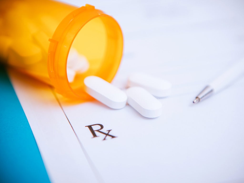 Tablets fallen out of pill bottle onto note pad