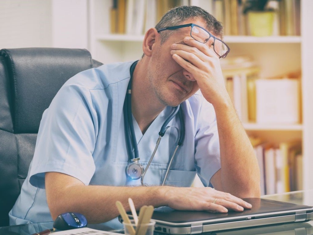 Doctor holding his head in his hands
