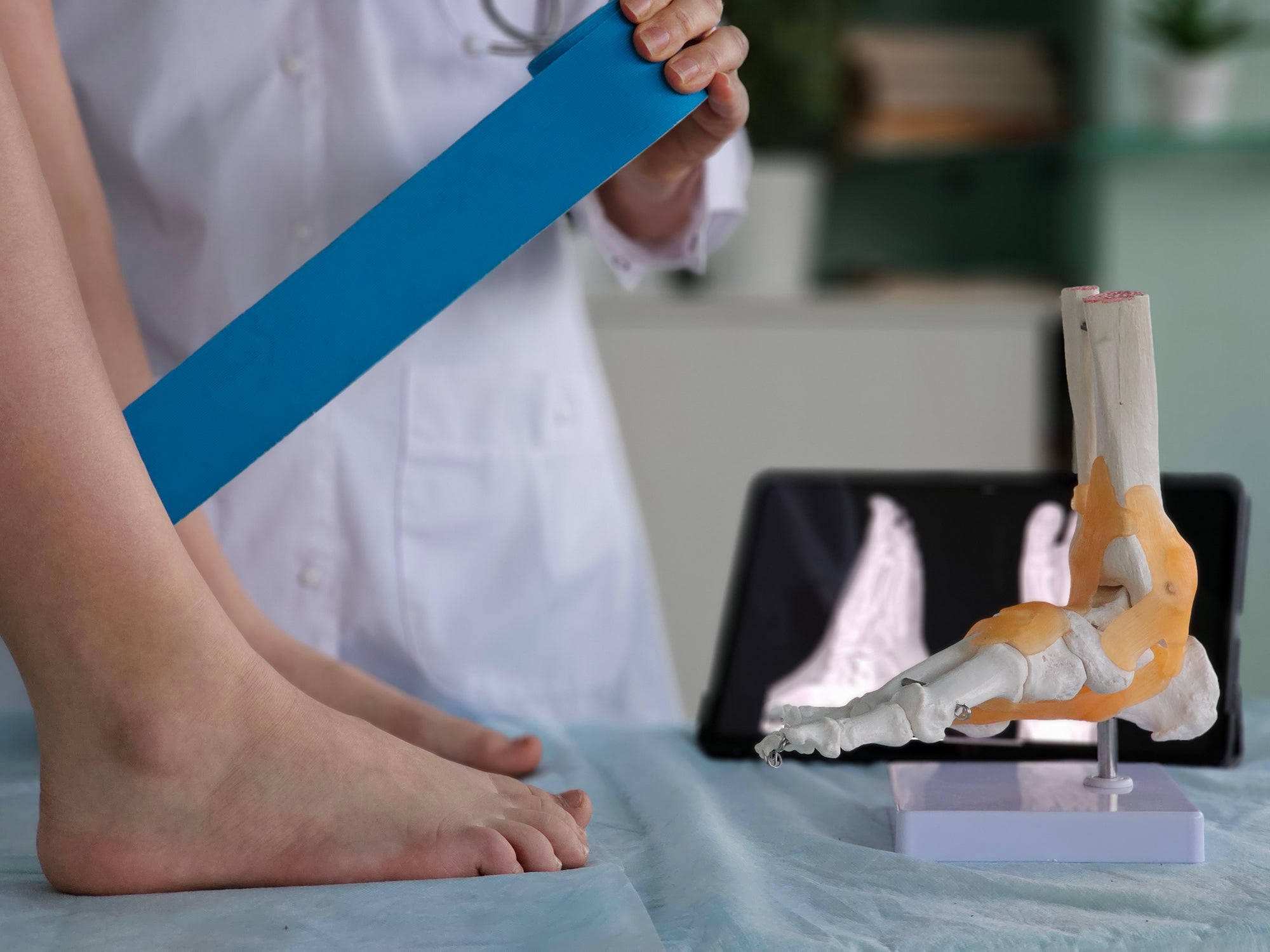 Doctor strapping ankle and ankle x-ray 