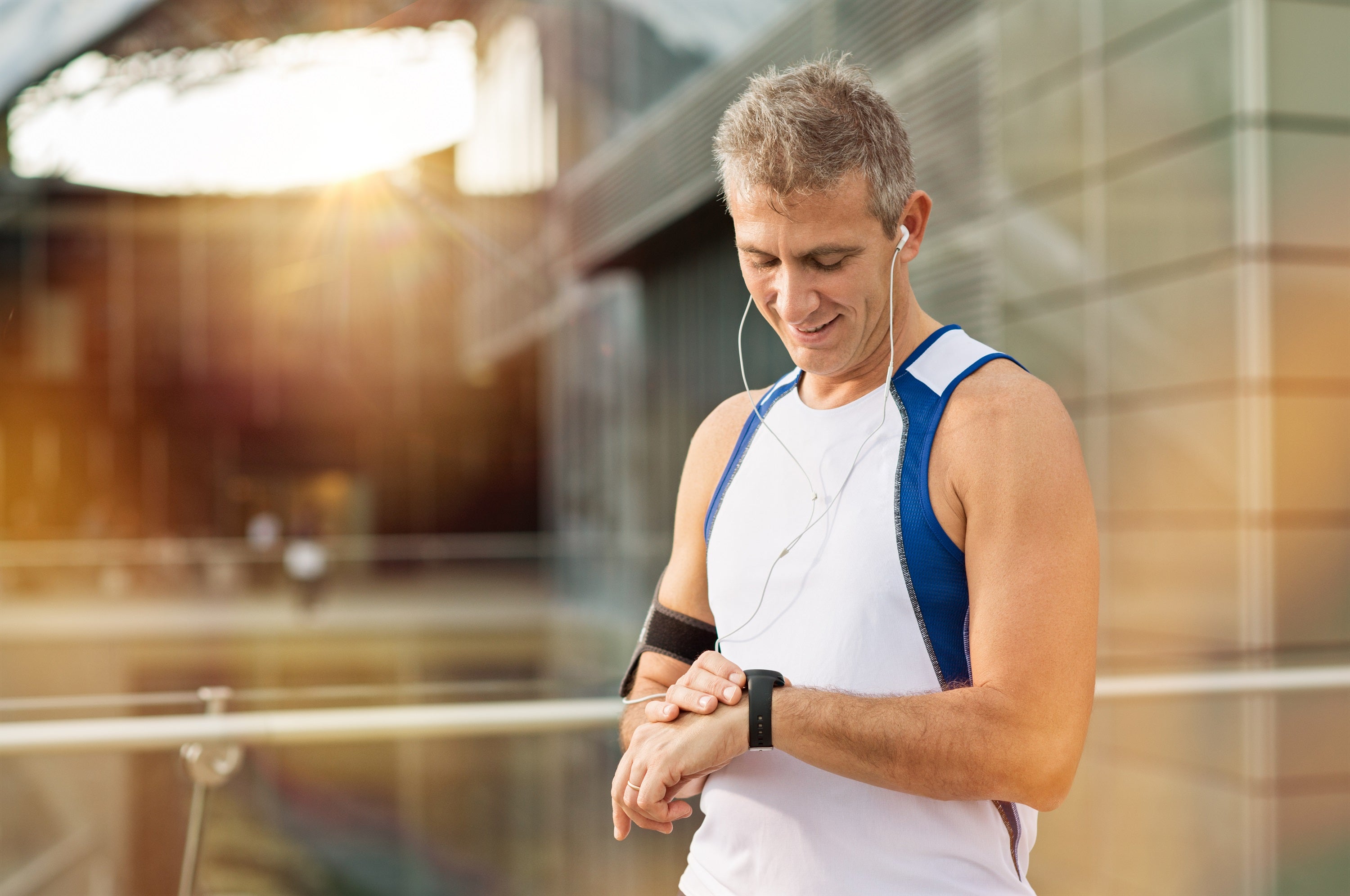 Man in active wear with headphones and fitness watch.
