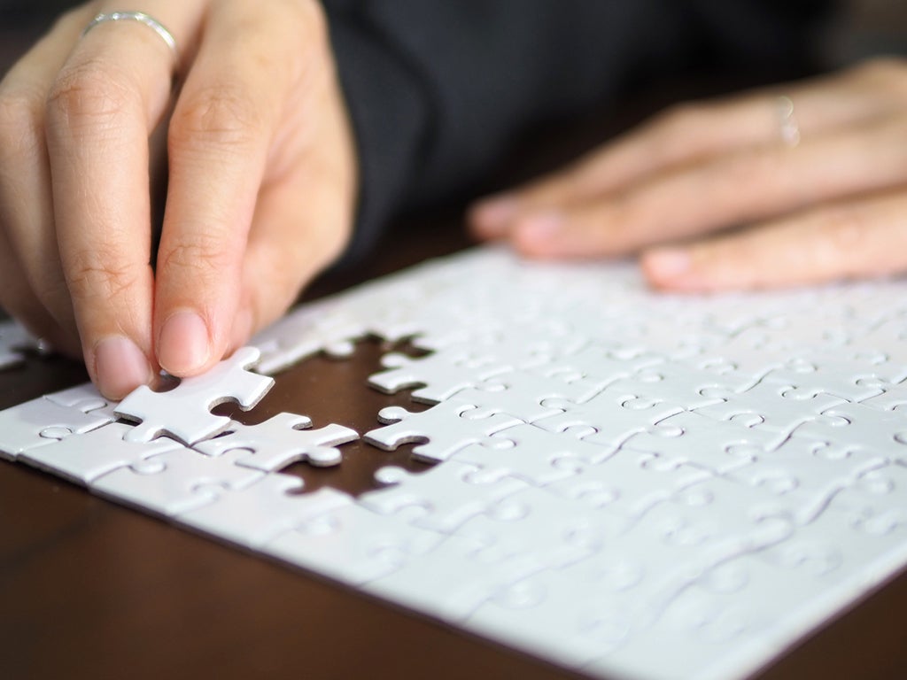 person putting together a jigsaw