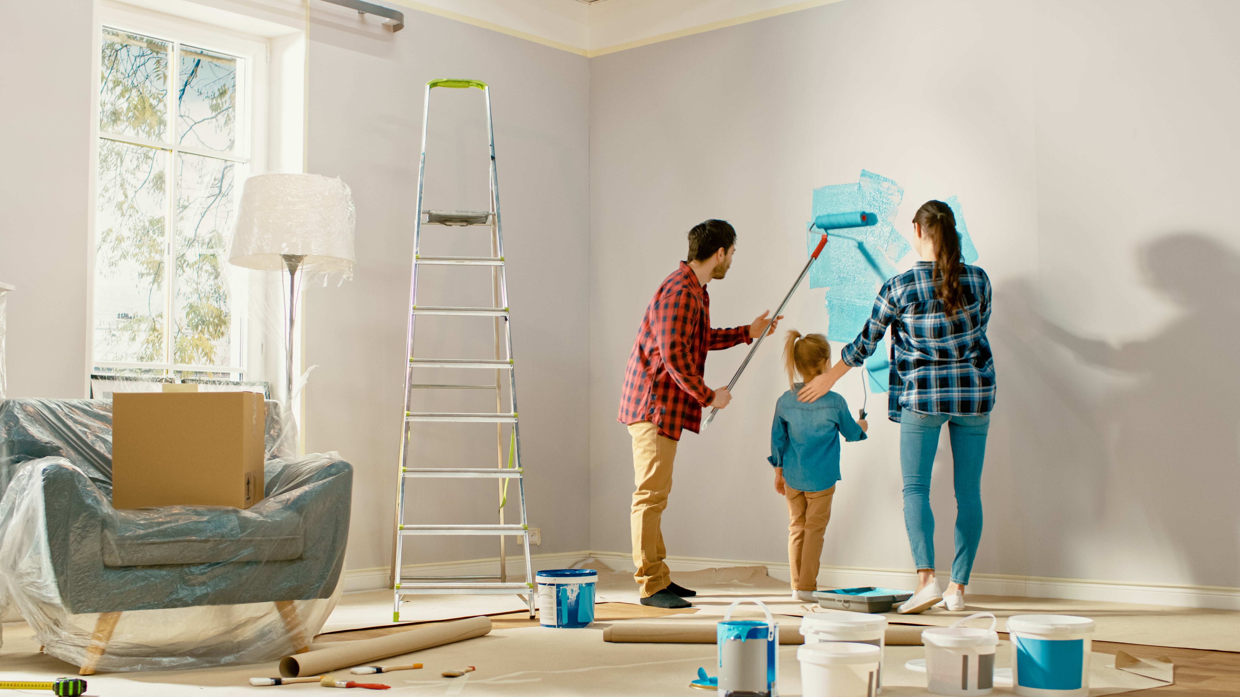 Family in home painting a wall.