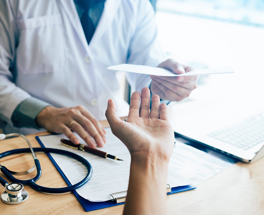 Photo of doctor handing paper to someone