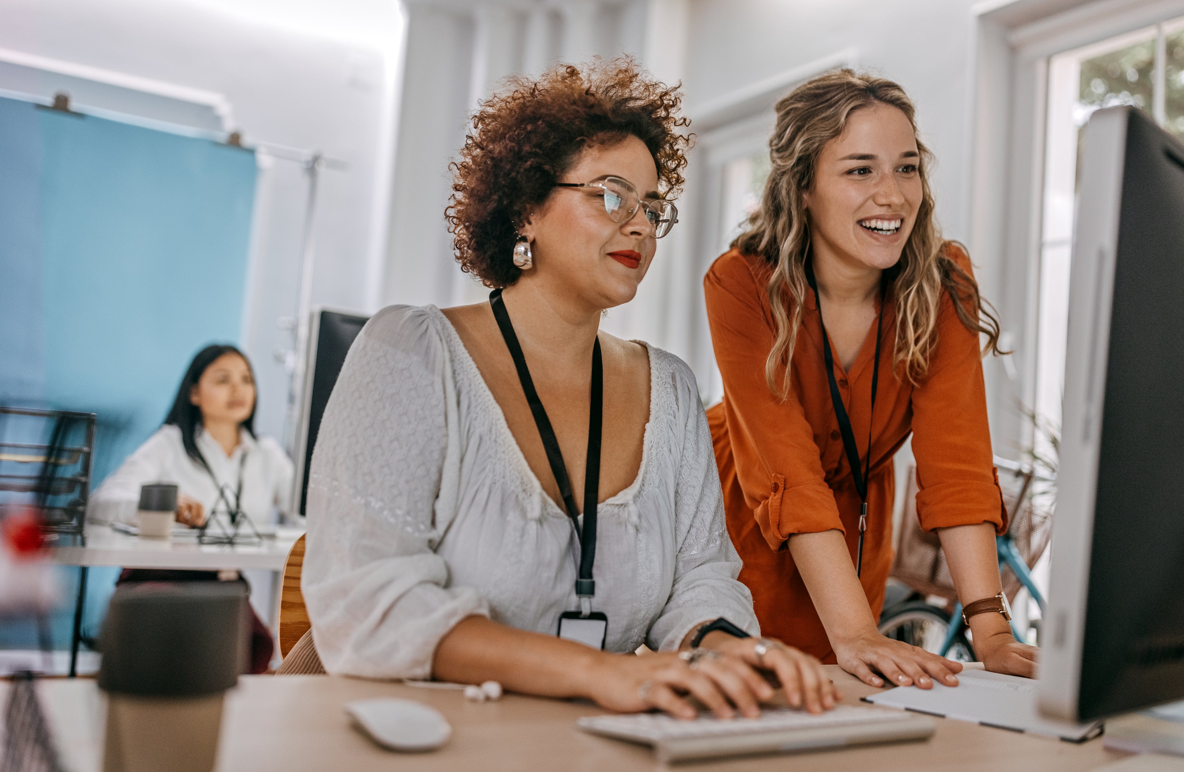 People smiling and working in front of computer