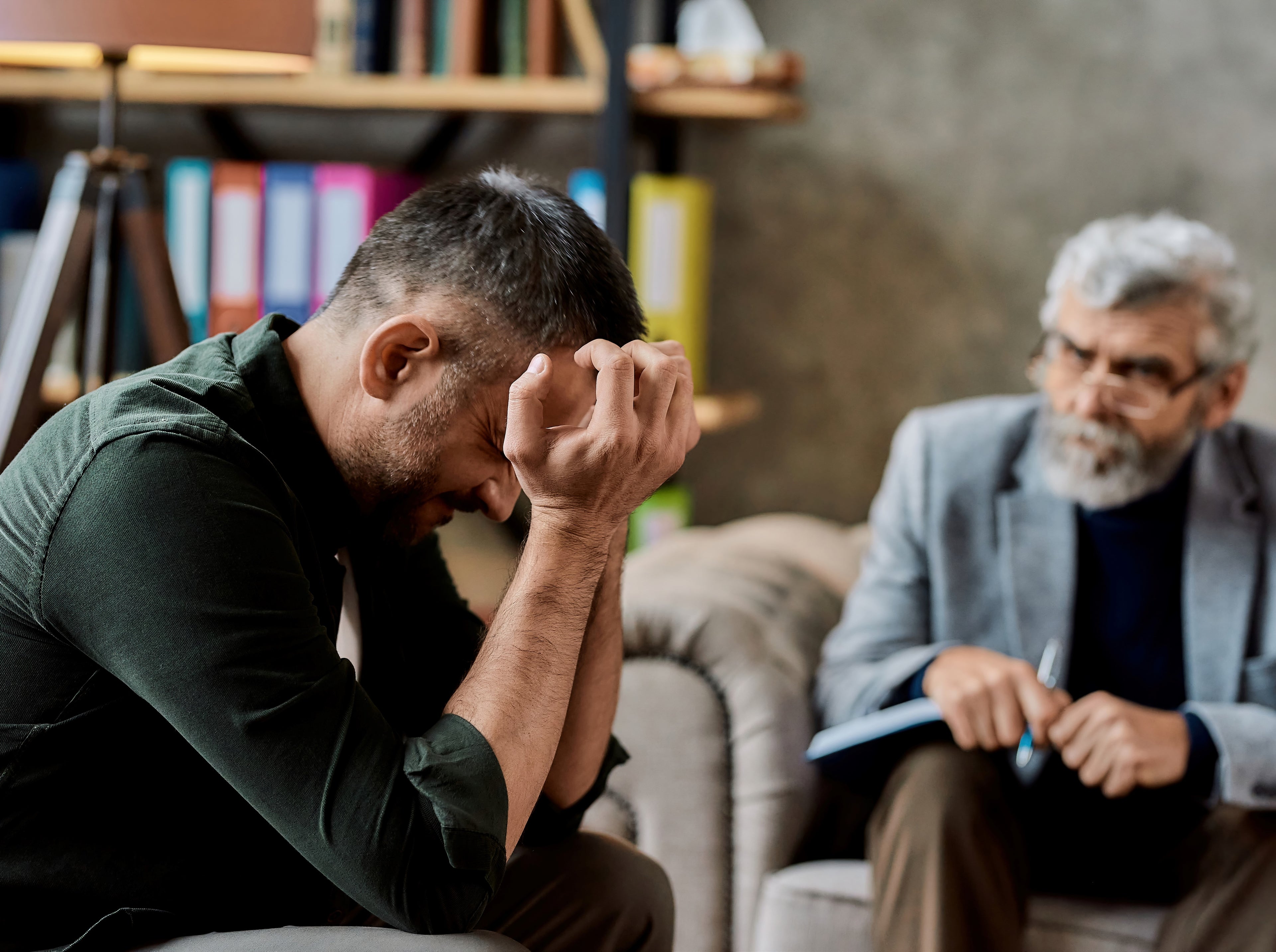 patient updated holding head in hands with doctor in background