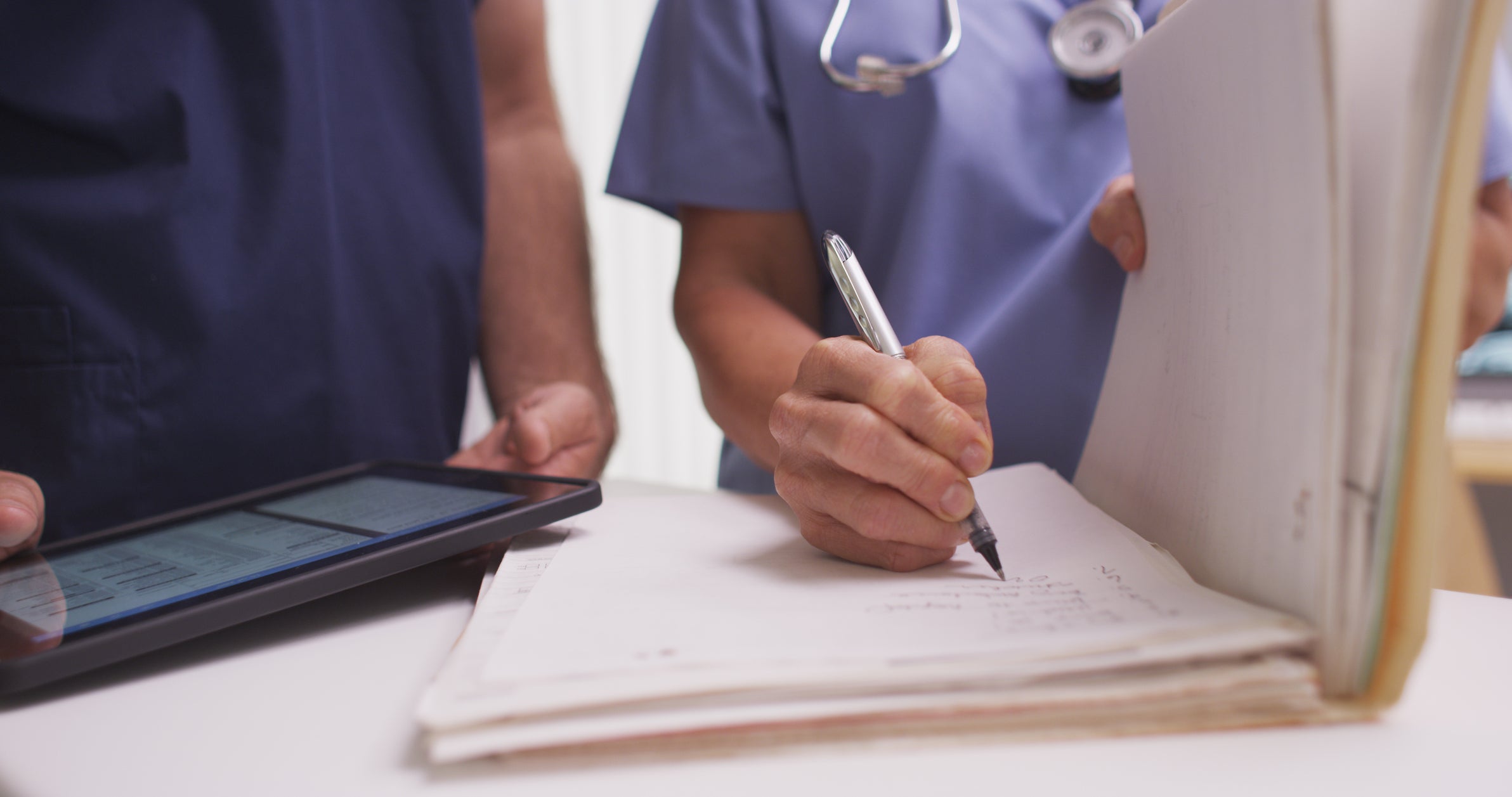 Female doctor writing on a medical record