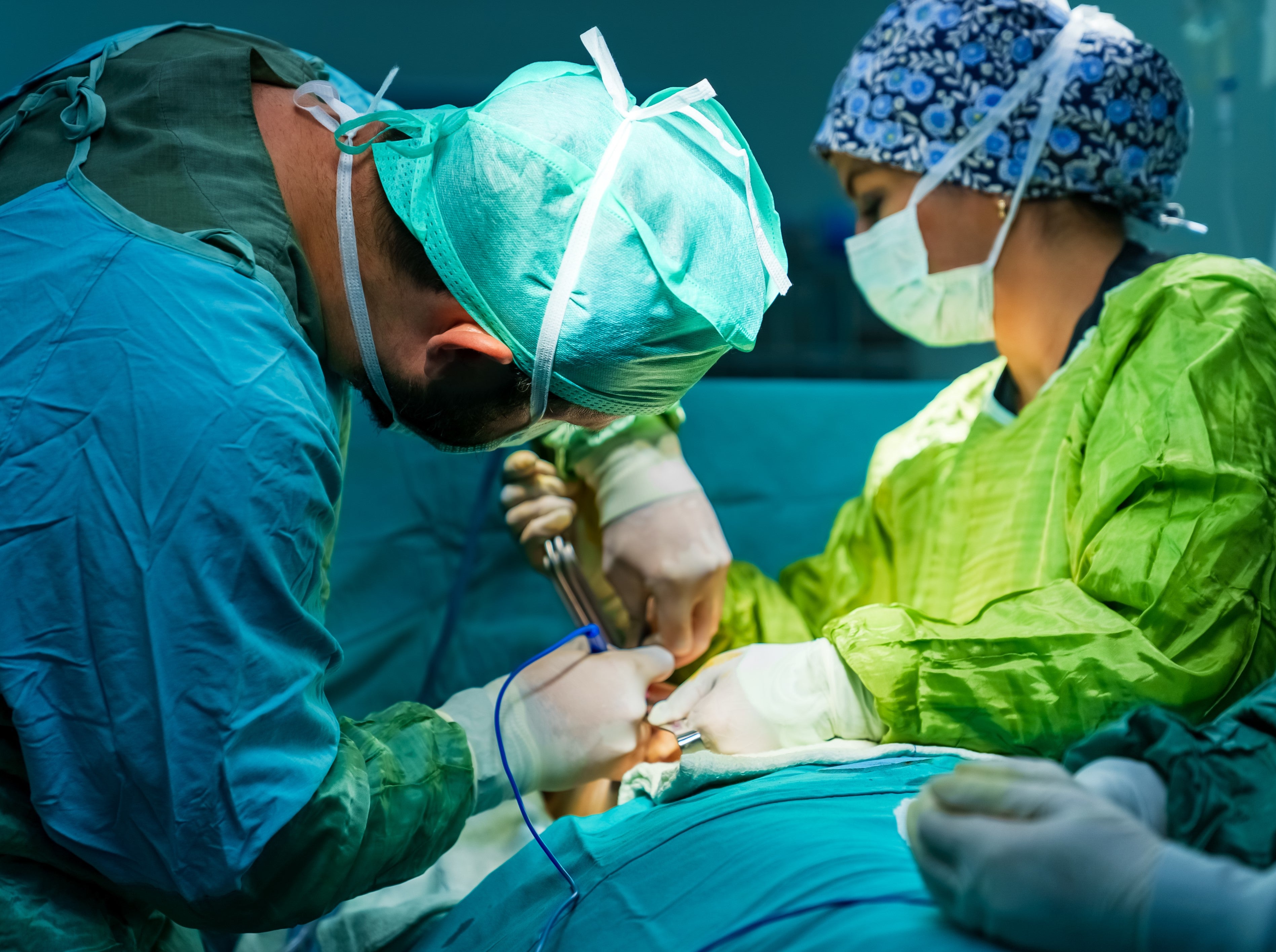 Surgeon in operating theatre with scrub nurse