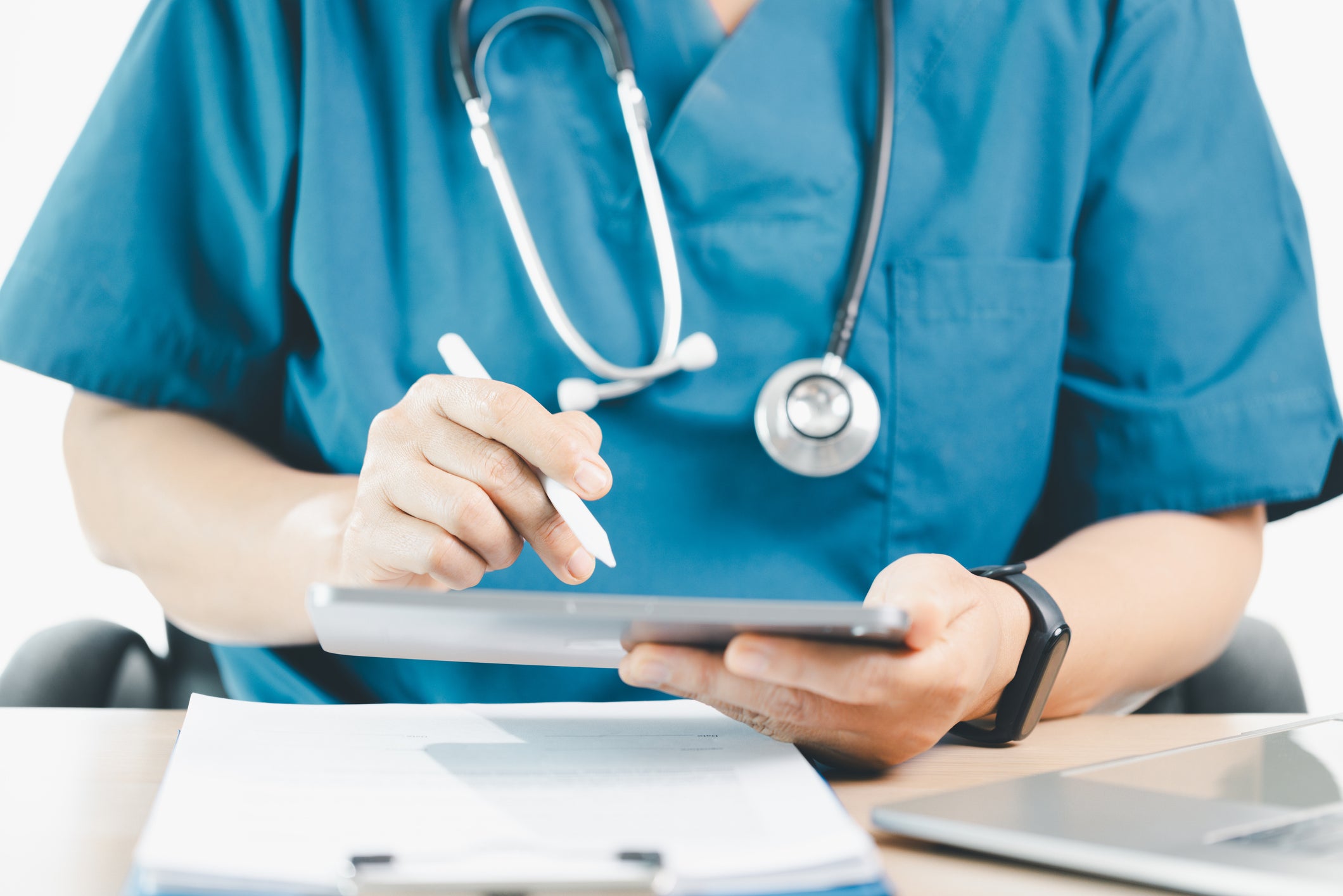 doctor in scrubs looking at checklist