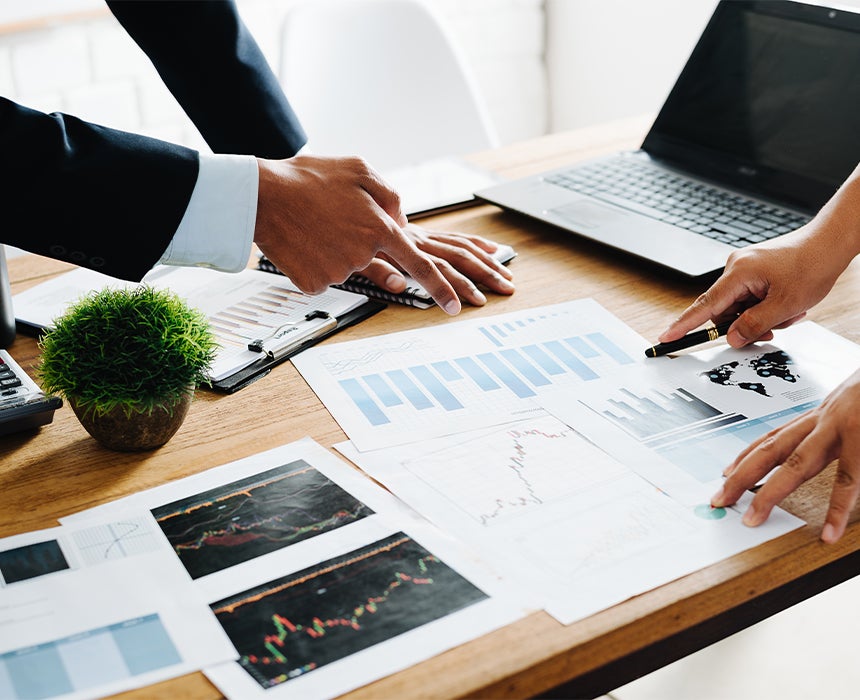 2 people discussing over a table with paper in front of them