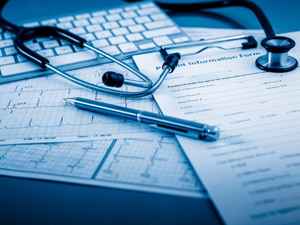 ECG, stethoscope and pen lying on computer keyboard