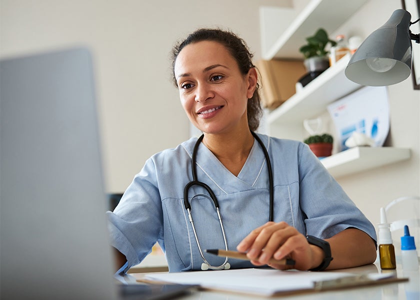 doctor smiling and working on their laptop