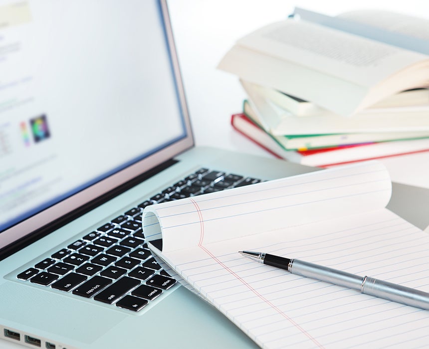 Computer and pile of text books