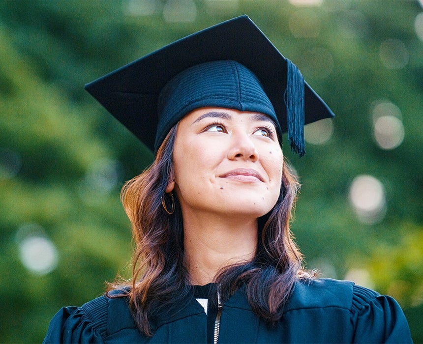 A woman wearing an academic mortarboard looking skyward