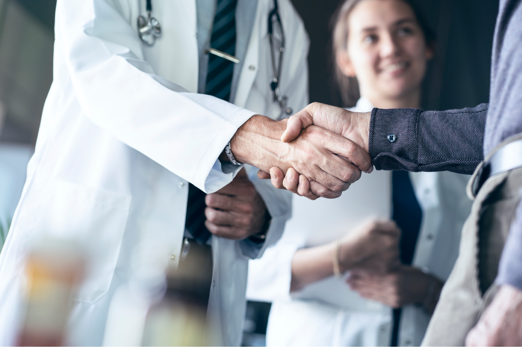 Doctor shaking hands with another person.