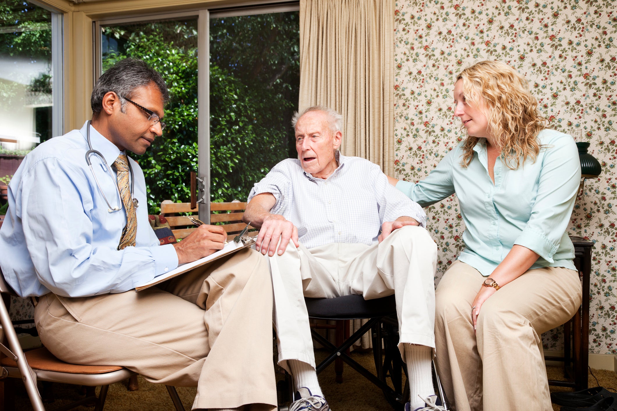 doctor with elderly man and his daughter 