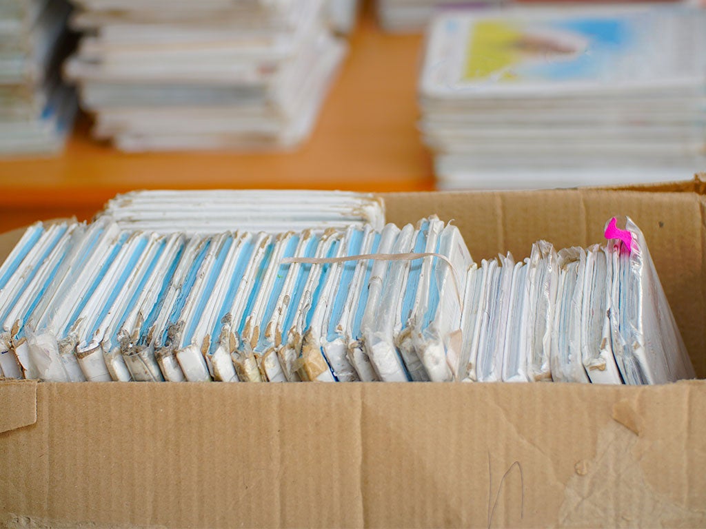 Old patient paper files sitting in a box on the ground