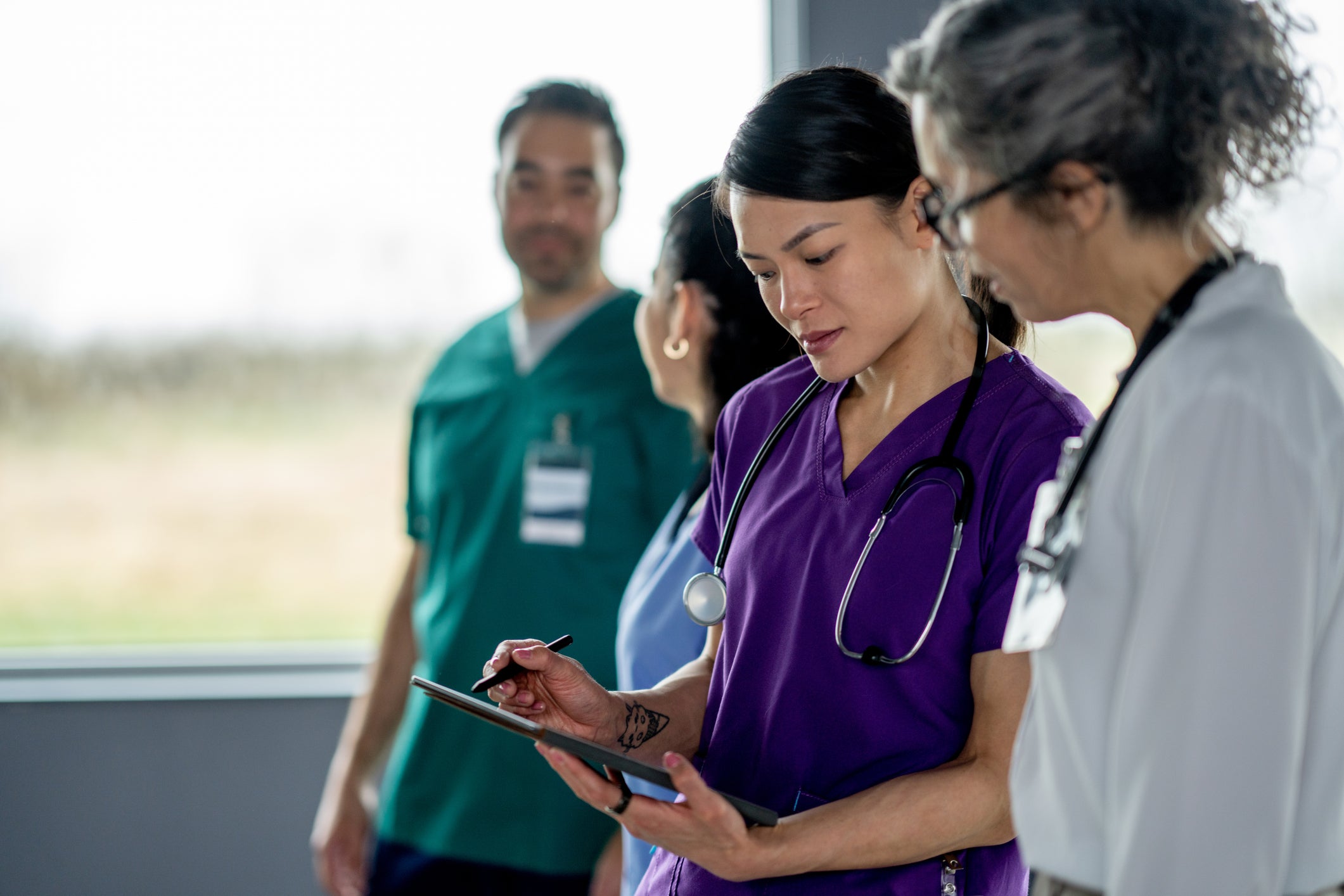 doctor in scrubs looking at checklist