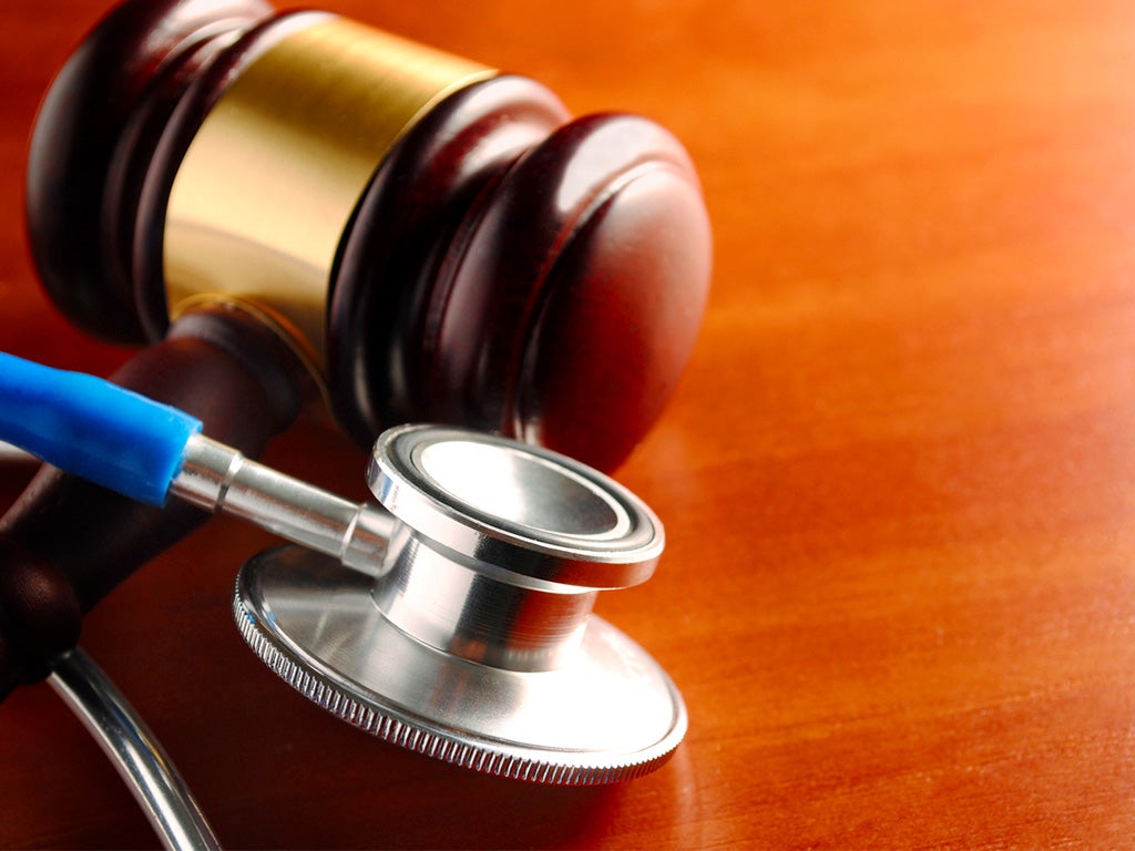 Gavel and stethoscope on wooden surface