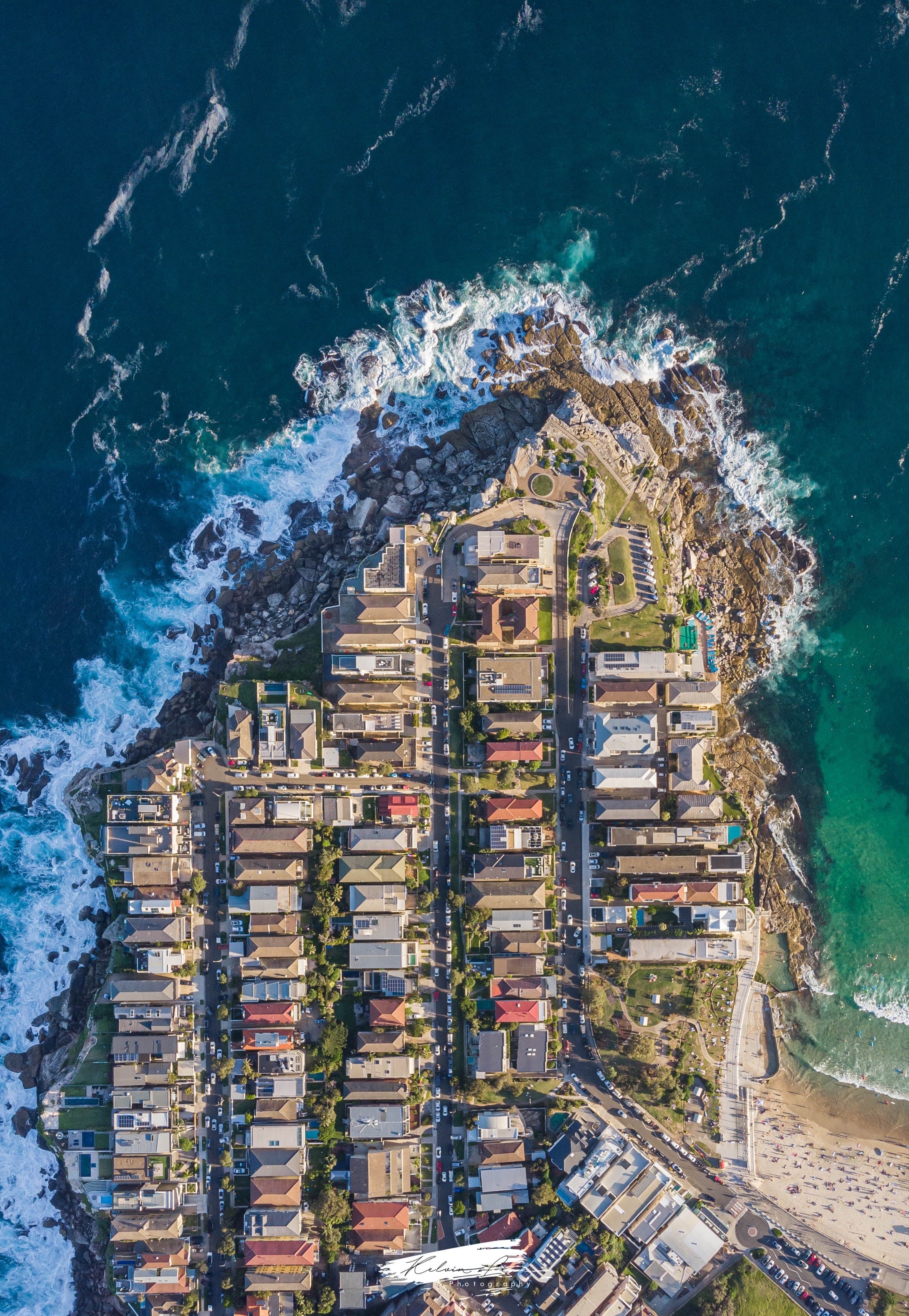 Aerial image of coastline featuring several homes. 