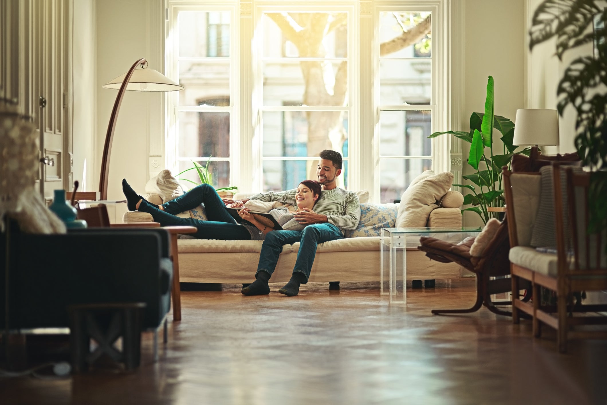 Couple laying on a couch inside their home. 