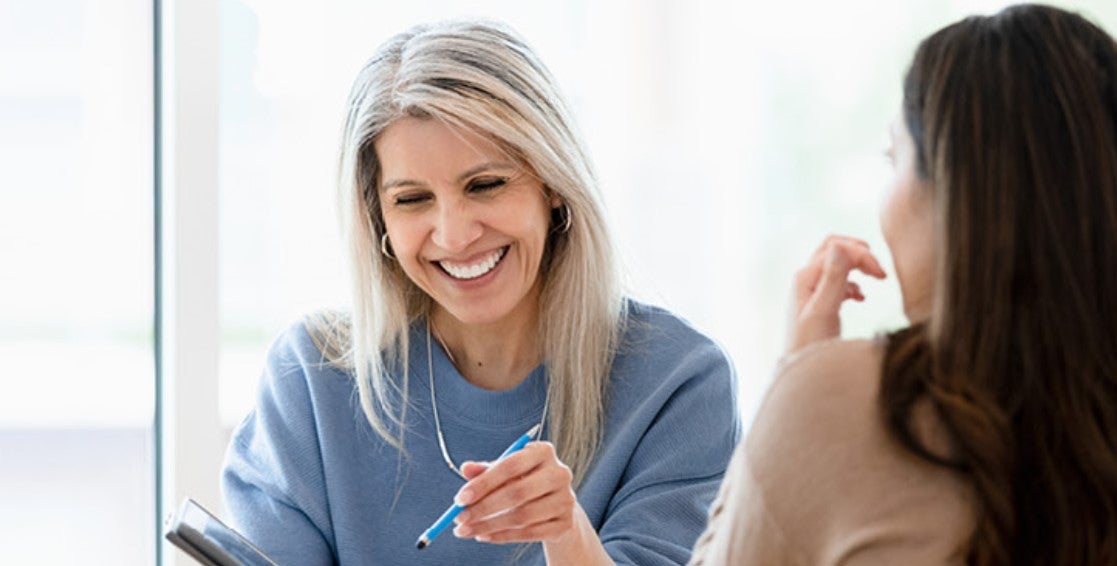 smiling woman discussing with client over a tablet