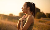 Female standing outside taking a deep breath