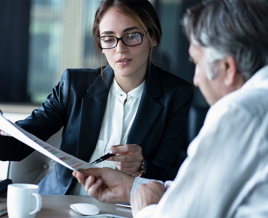 A professional and customer sitting reviewing file