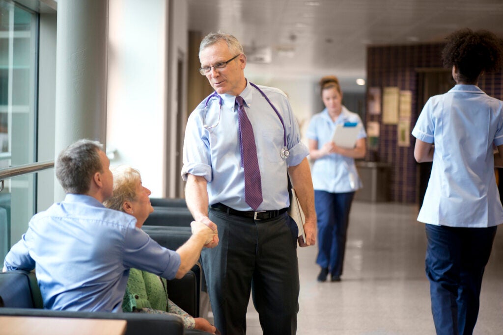 Doctor greeting patient in waiting room 