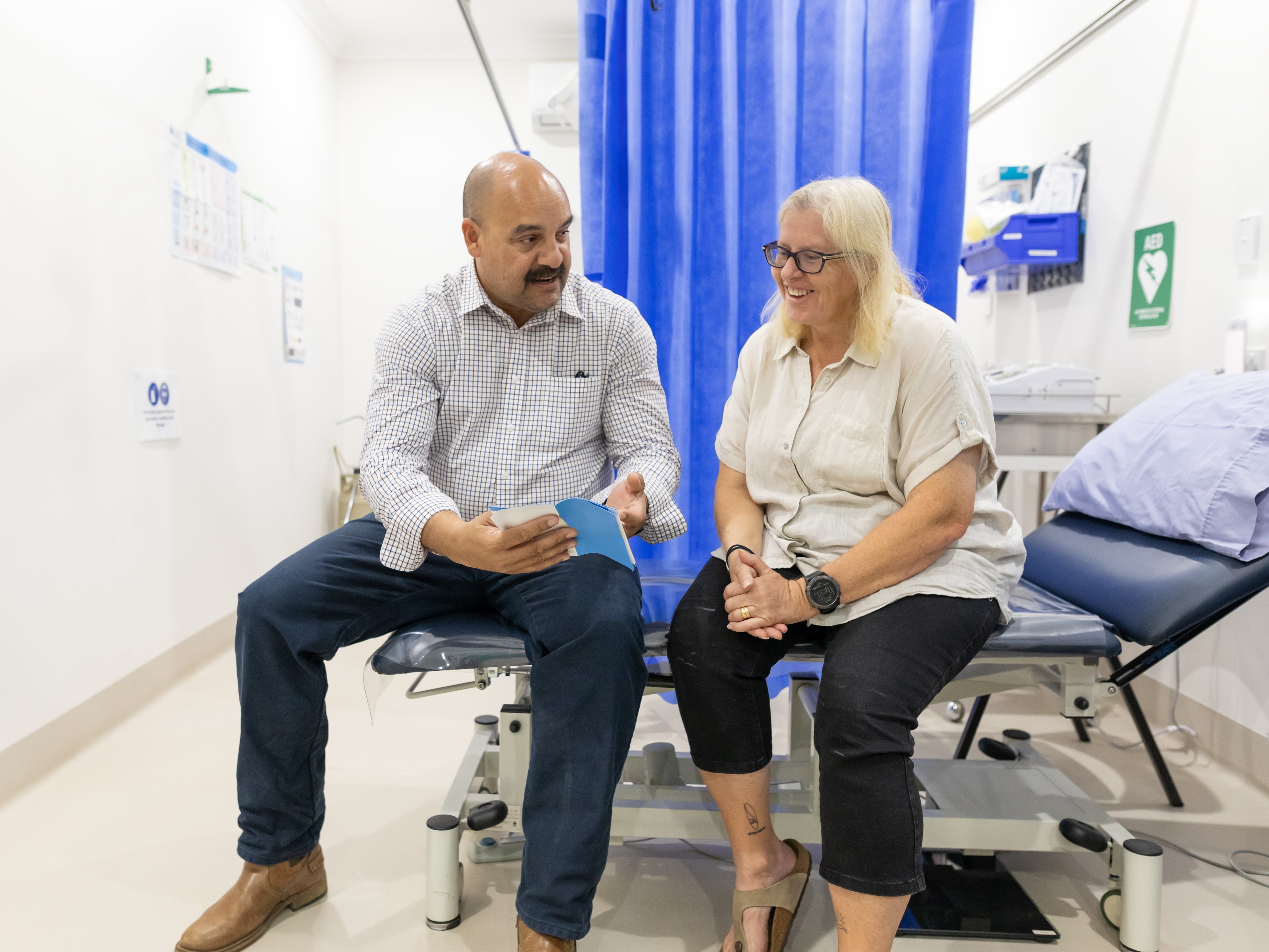 Doctor and patient talking on hospital cubical bed